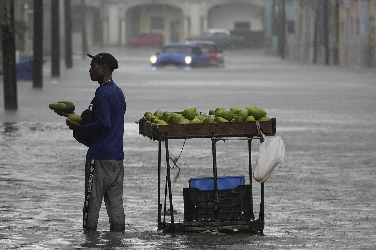 Bokáig érő vízben árul avokádót egy férfi Havannában az Idalia hurrikán elvonulása után 2023. augusztus 29-én.