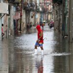 Gyalogos kel át egy árvízzel elöntött utcán az Idalia hurrikán elvonulása után Havannában 2023. augusztus 29-én.