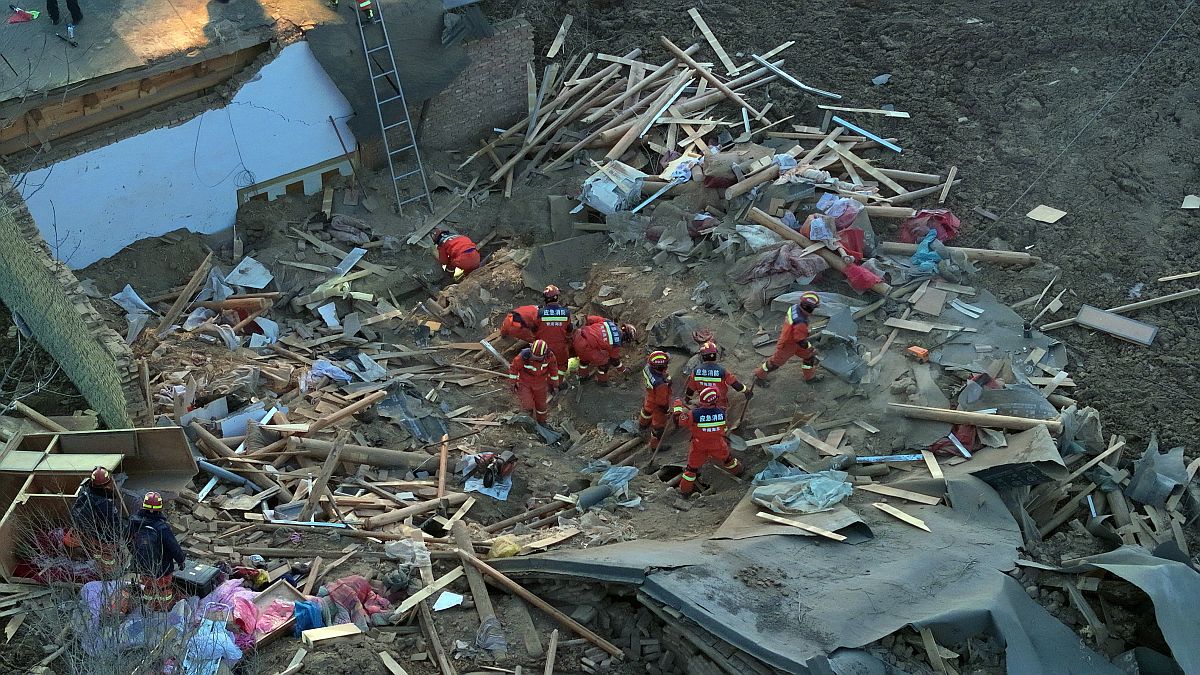 Túlélőket keresnek a mentőegység tagjai egy összedőlt épület törmeléke közt a Kanszu tartománybeli Caotan faluban.
