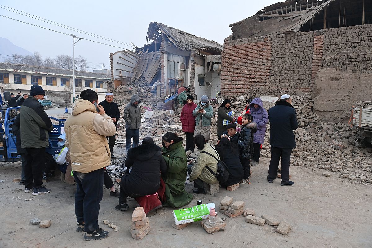 Utcán melegedő emberek a kínai földrengés helyszínén.